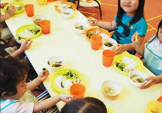 夜間幼稚園でご飯を食べる子供